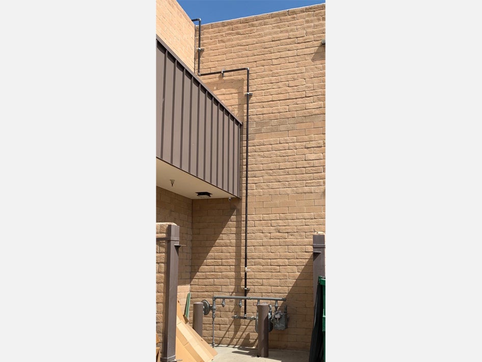 Exterior plumbing on brick wall